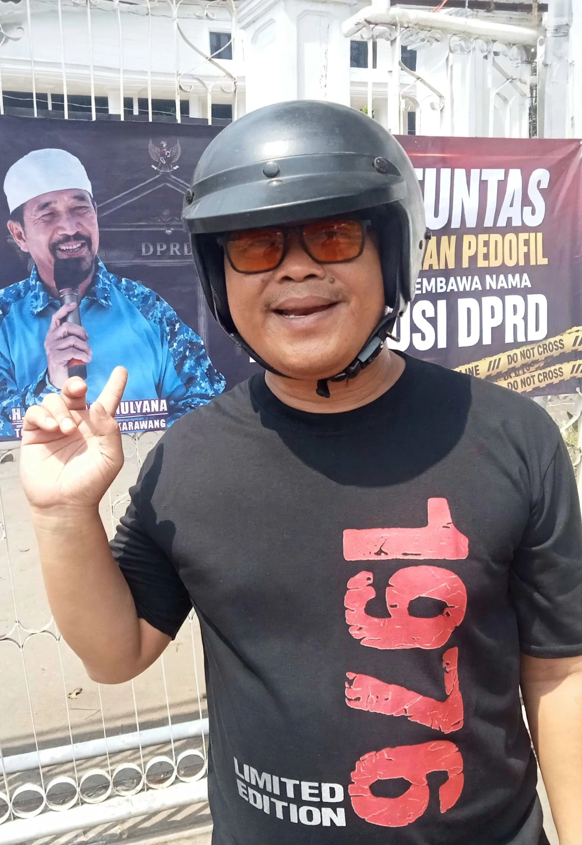 Tangkapan layar aktivis Karawang, Danton sedang menunjukan spanduk satir yang ia pasang di gerbang DPRD Karawang.